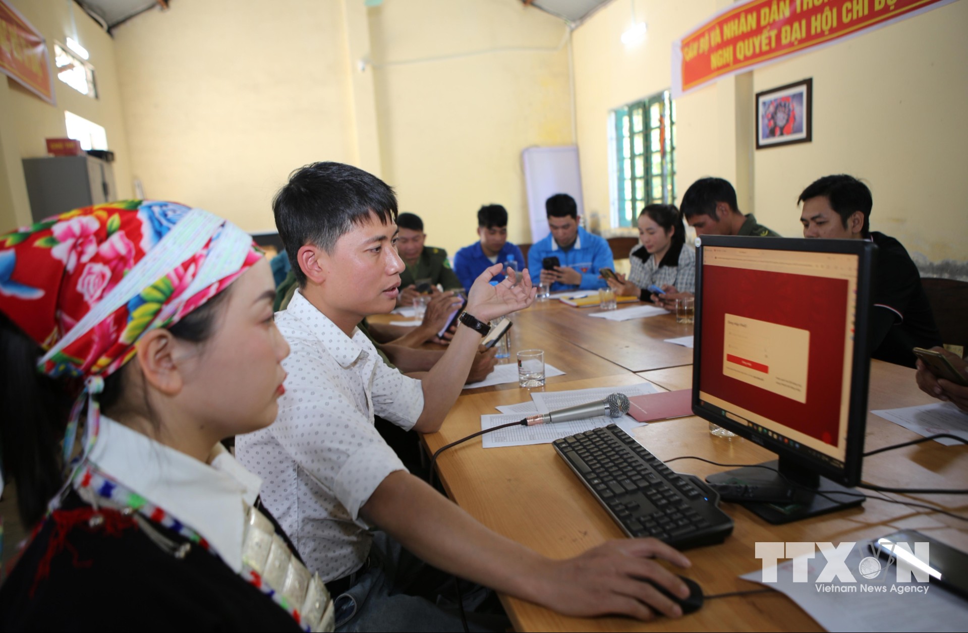 Hướng dẫn người dân thôn Sơn Hà, xã Bát Xát thực hiện nộp hồ sơ trực tuyến trên cổng dịch vụ công. (Ảnh: TTXVN phát)